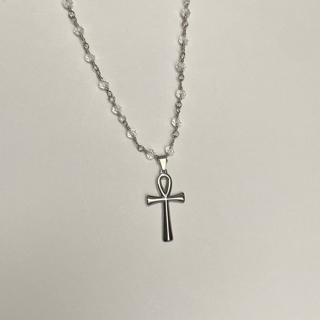 Necklace with silver colored ankh pendant on a clear beaded chain with silver colored links.