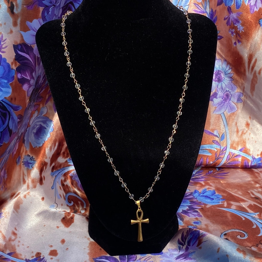 necklace made with a transparent beads beaded gold chain and a gold Ankh pendant.