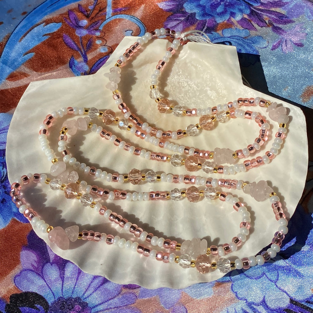 Pink and white waist beads made with rose quartz and facetted glass beads.