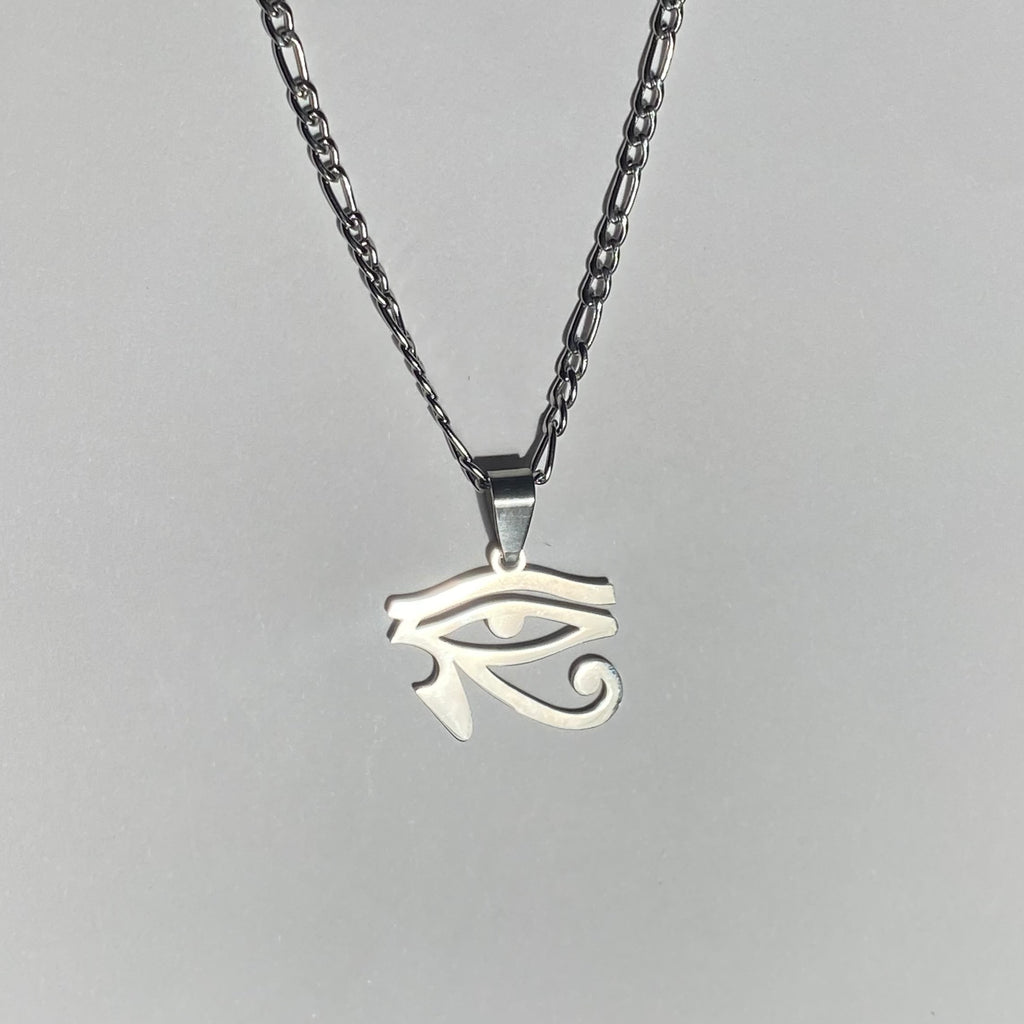 a necklace with silver colored chain and eye of ra pendant displayed on a light background.